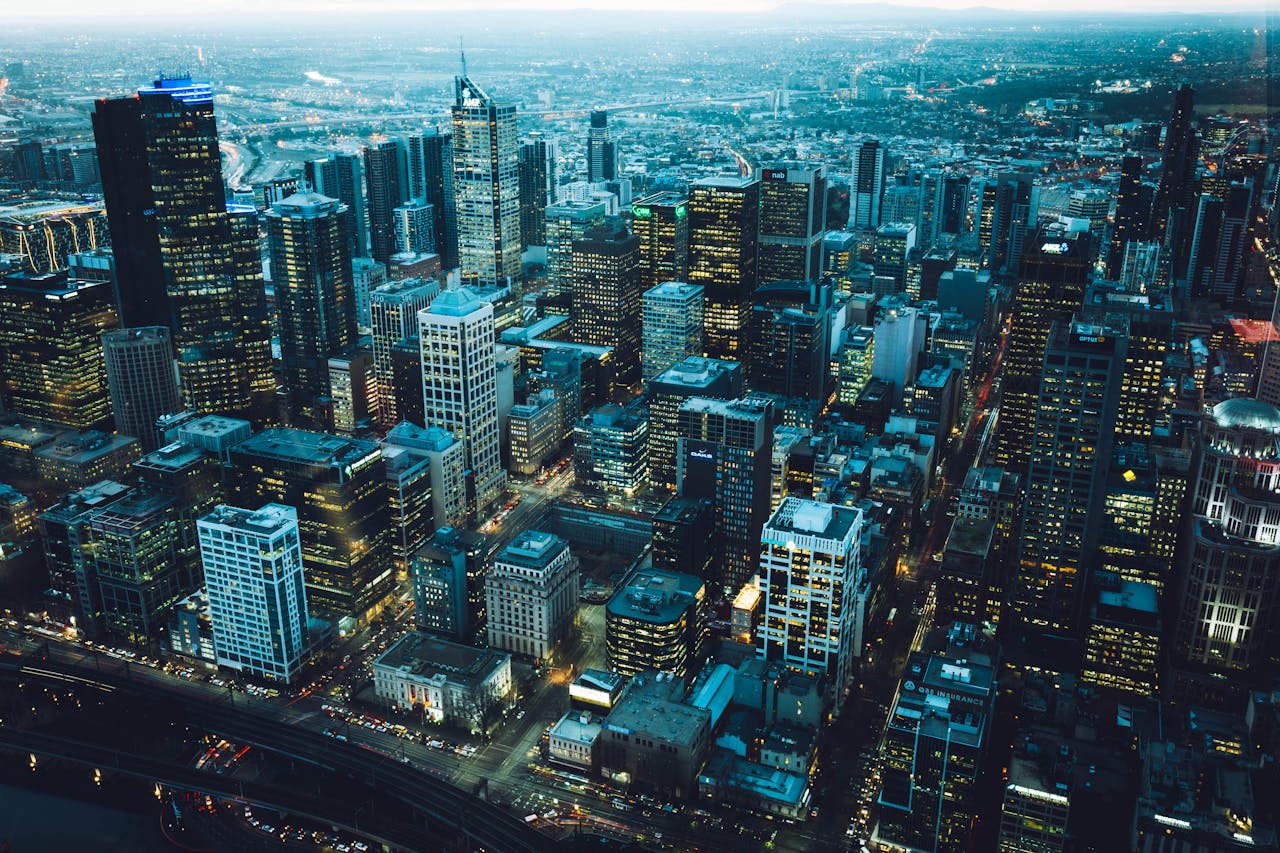 Captivating aerial view of a bustling city skyline at night with illuminated skyscrapers.